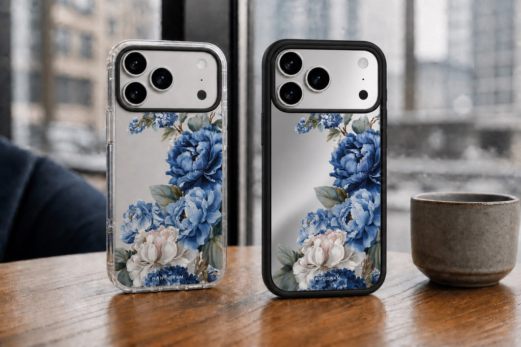 Hanogram Blue Elegance design shown on Clear and Mirror Cases for two iPhone 17 Pro Max phones at a café window